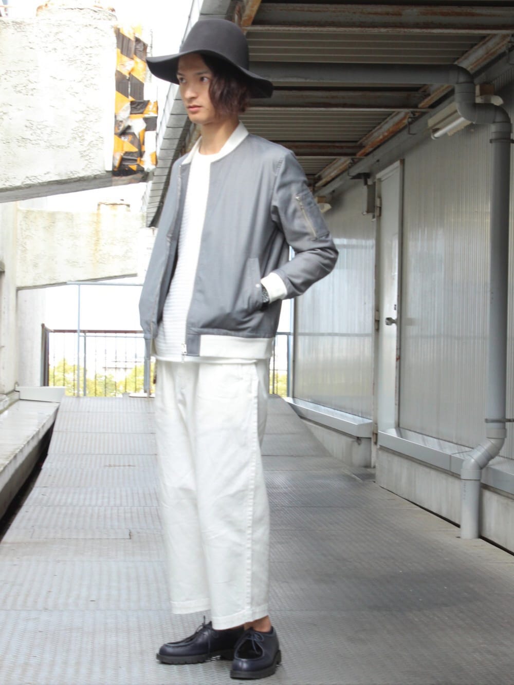 グレー系のMA-1、ホワイト系のパンツ、ブルー系のシューズを着用したメンズの春コーディネートの1枚目の写真