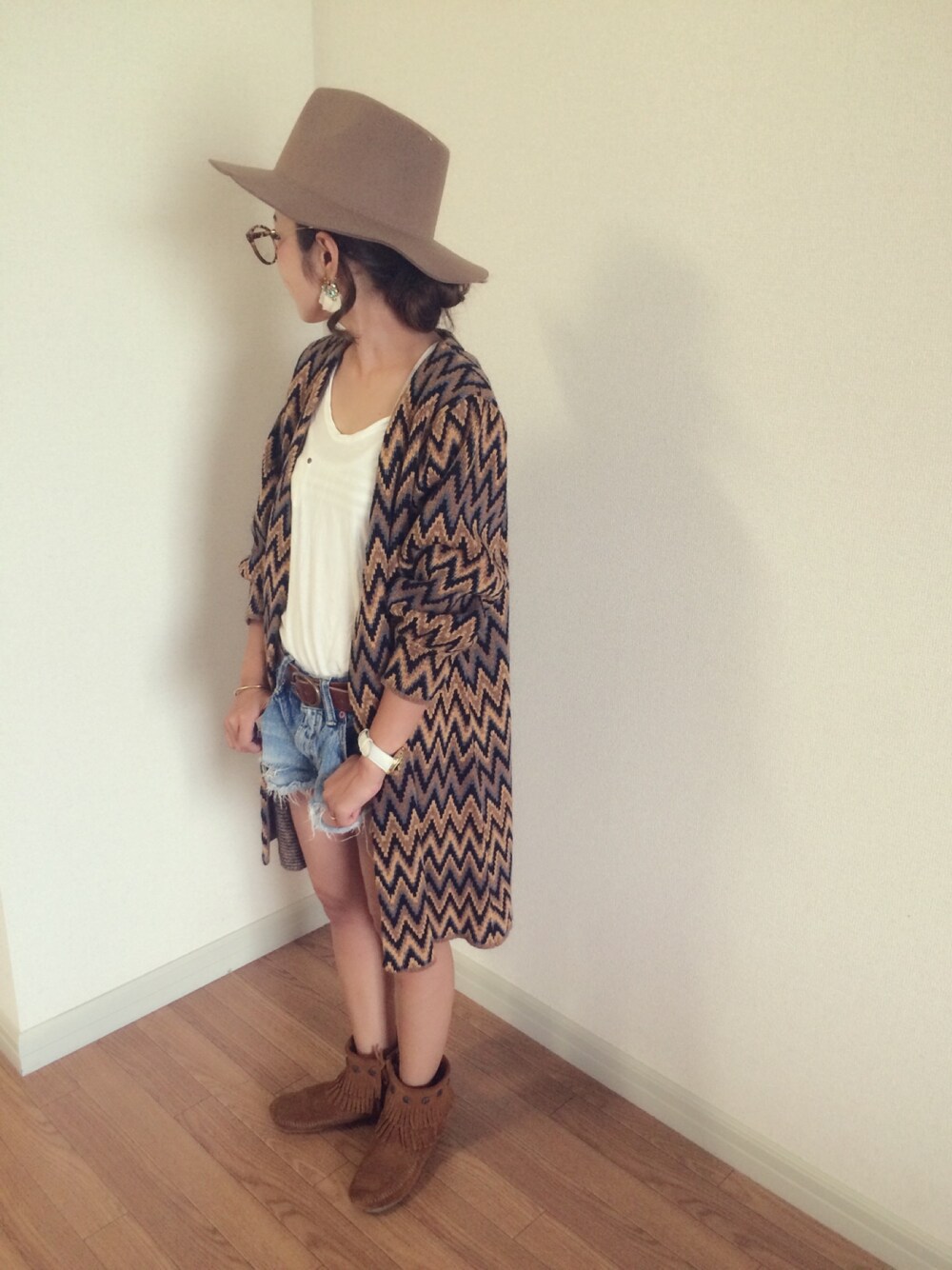 ブラウン系のカーディガン/ボレロ、ホワイト系のタンクトップ、ブルー系のデニムパンツを着用したレディースの秋コーディネートの1枚目の写真