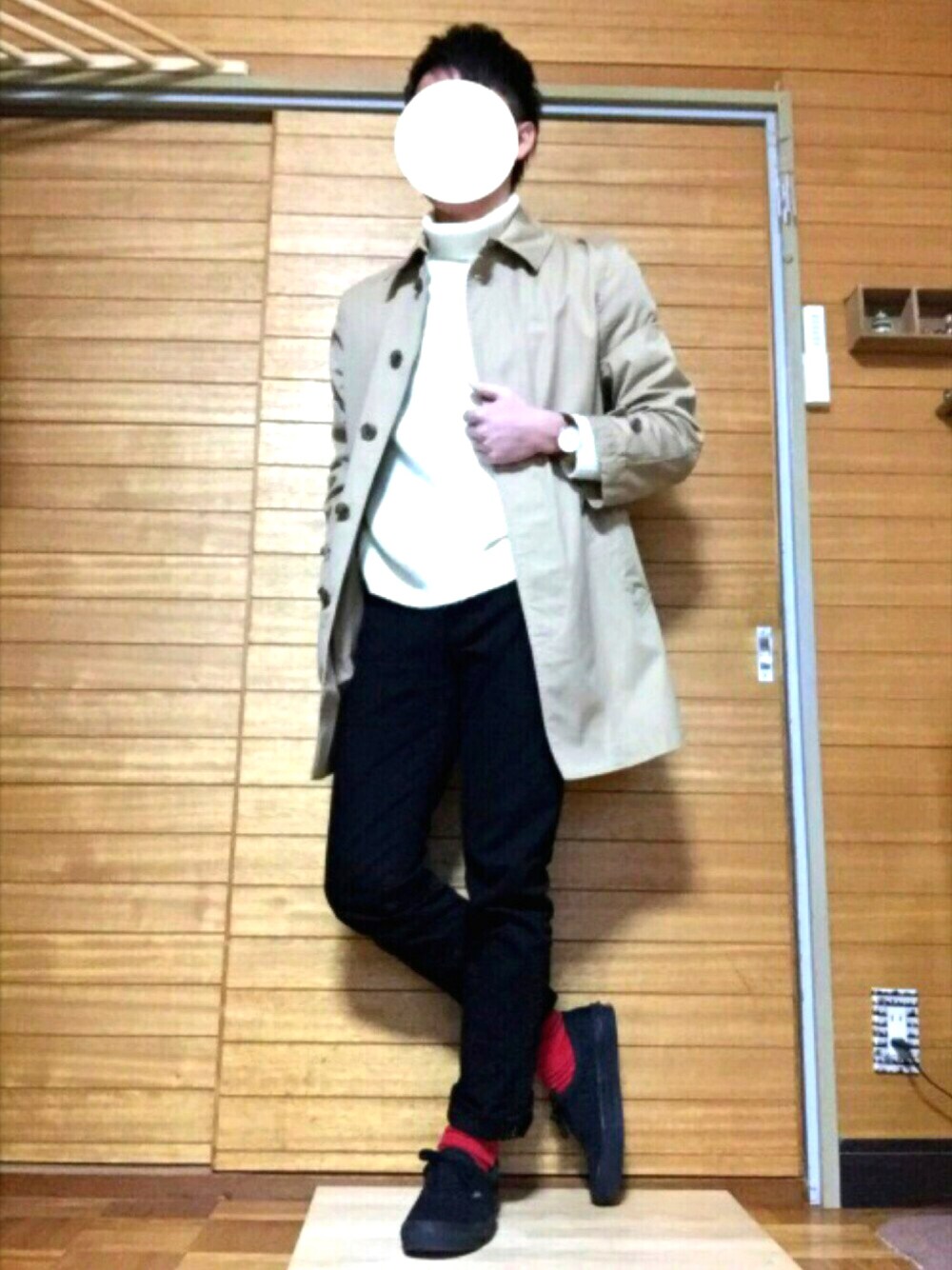 ベージュ系のステンカラーコート、ホワイト系のニット/セーター、ブラック系のデニムパンツを着用したメンズの冬コーディネートの1枚目の写真