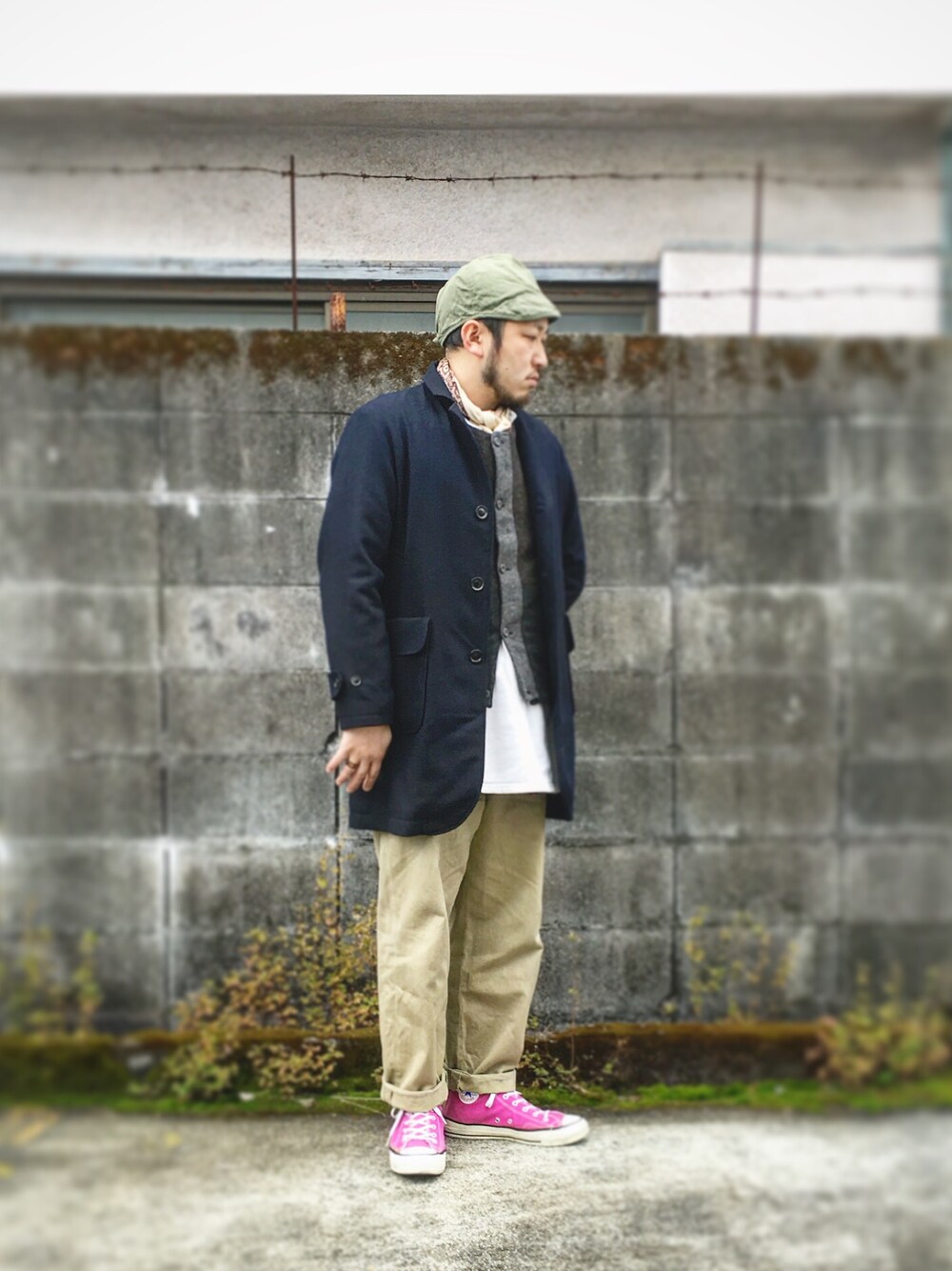 ブラック系のチェスターコート、ベージュ系のチノパンツ、ピンク系のスニーカーを着用したメンズの冬コーディネートの1枚目の写真