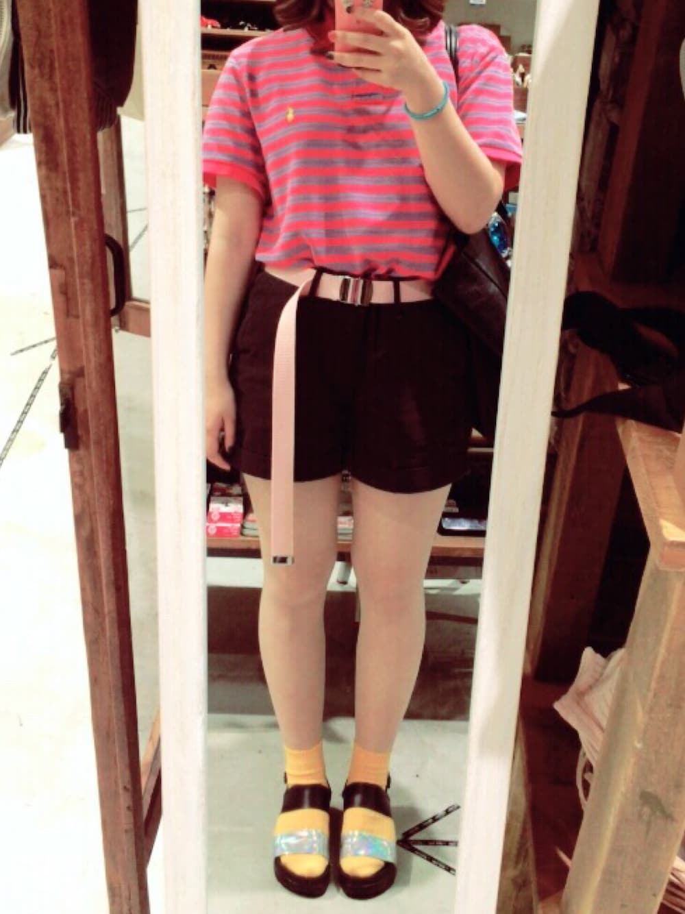 ピンク系のポロシャツ、ブラック系のデニムパンツ、ブラック系のサンダルを着用したレディースの夏コーディネートの1枚目の写真