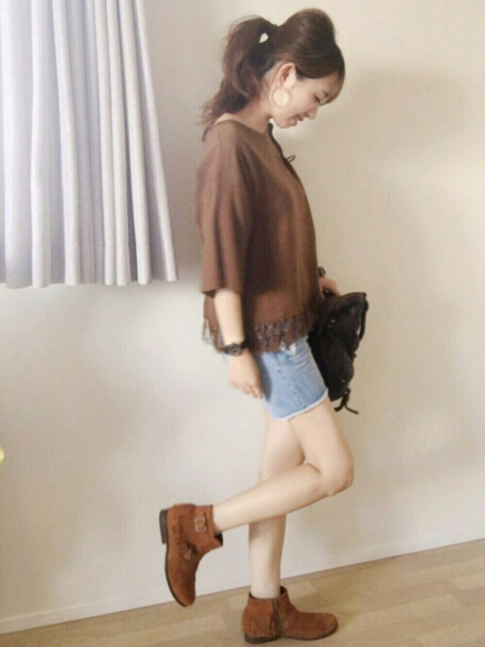 ブルー系のパンツ、ブラウン系のブーツ、ブラウン系のバッグを着用したレディースの夏コーディネートの1枚目の写真