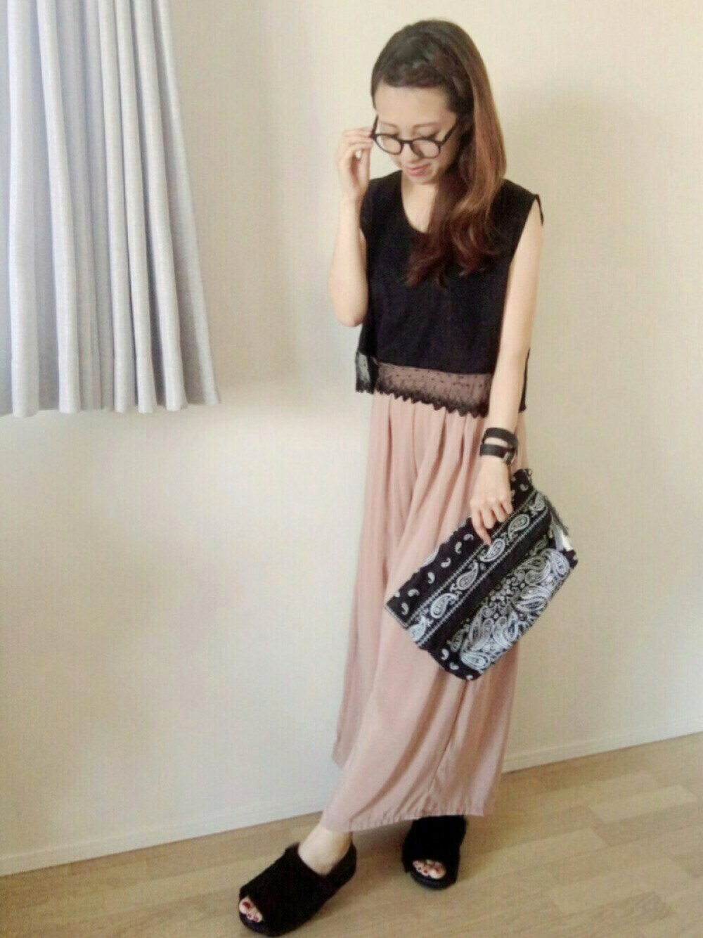 ピンク系のパンツ、ブラック系のサンダル、ブラック系のトップスを着用したレディースの秋コーディネートの1枚目の写真