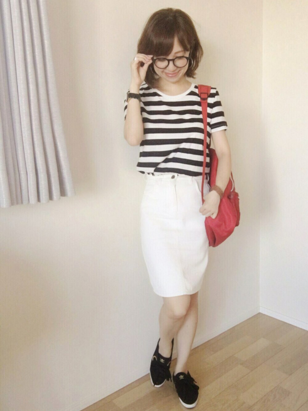 ブラック系のスニーカー、ホワイト系のスカート、ブラック系のTシャツ/カットソーを着用したレディースの秋コーディネートの1枚目の写真