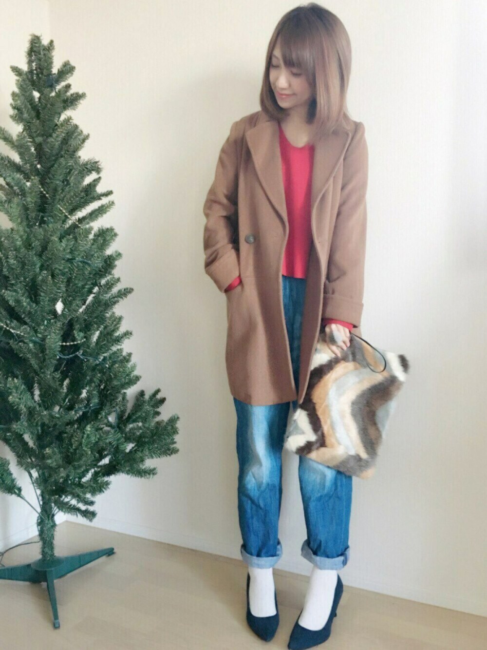 ブルー系のデニムパンツ、ブルー系のパンプス、ホワイト系のクラッチバッグを着用したレディースの秋コーディネートの1枚目の写真