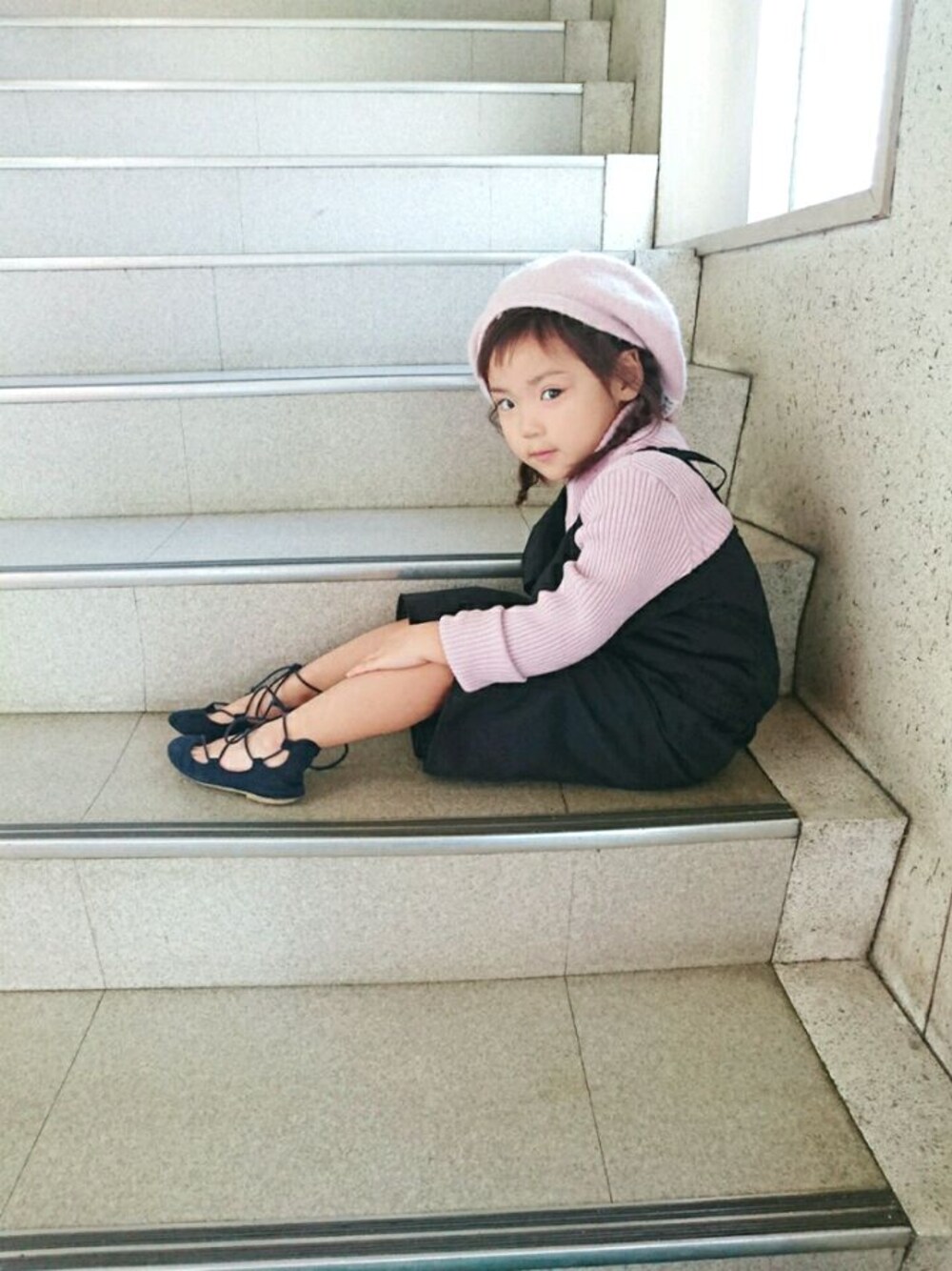 ピンク系のニット/セーター、ブラック系のサロペット/オーバーオール、ブラック系のパンプスを着用したキッズの秋コーディネートの1枚目の写真