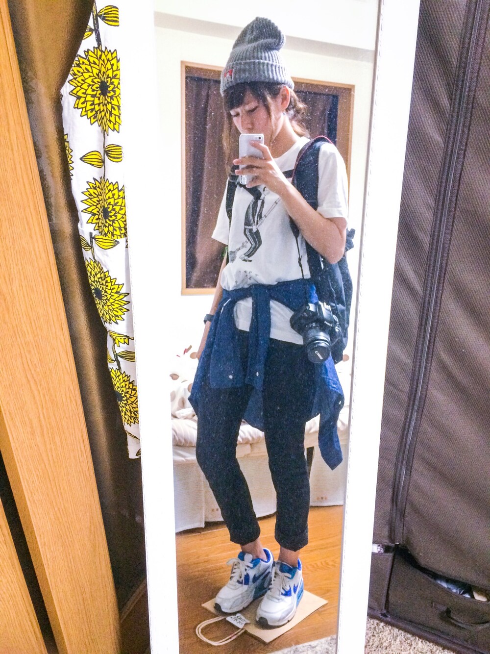 ブラック系のバックパック/リュック、ホワイト系のTシャツ/カットソー、ブルー系のシャツ/ブラウスを着用したレディースの秋コーディネートの1枚目の写真