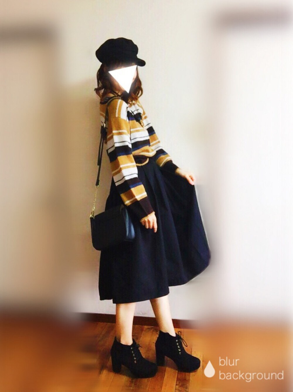 イエロー系のニット/セーター、ブラック系のスカート、ブラック系のショルダーバッグを着用したレディースの秋コーディネートの1枚目の写真