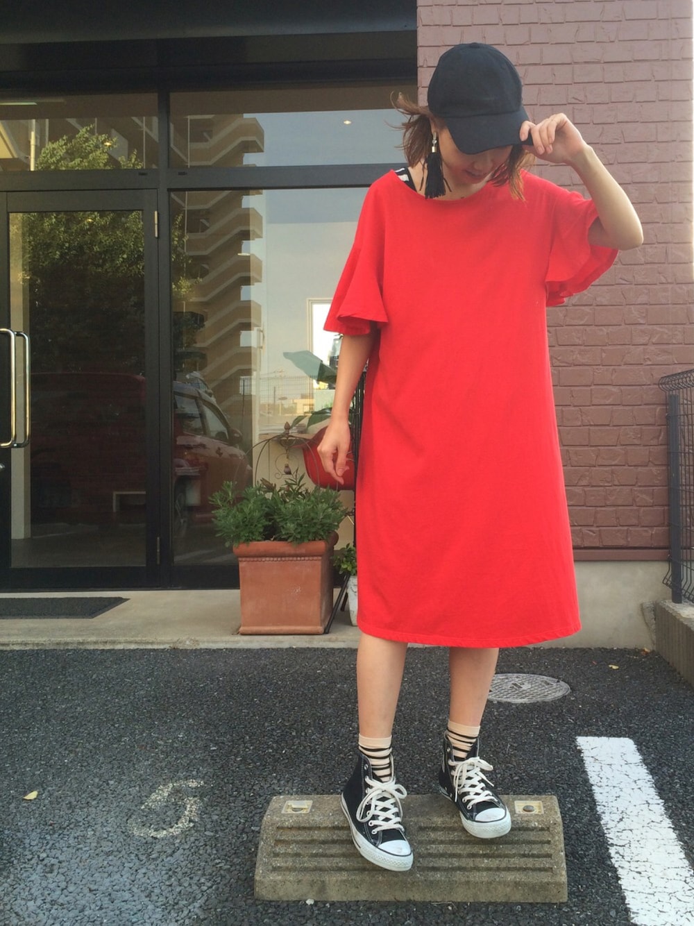 レッド系のワンピース、その他のタンクトップ、ブラック系のスニーカーを着用したレディースの夏コーディネートの1枚目の写真