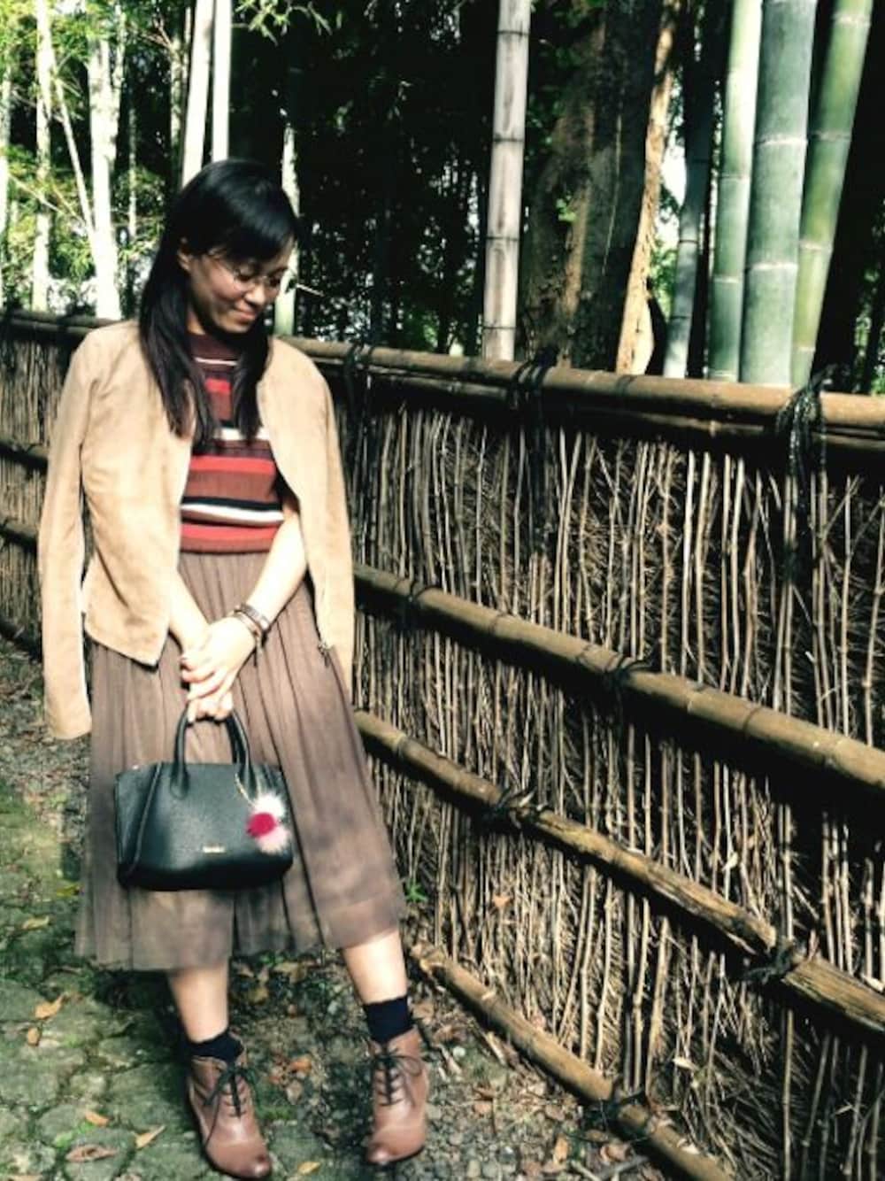 ベージュ系のノーカラージャケット、ブラウン系のニット/セーター、ブラック系のタンクトップを着用したレディースの秋コーディネートの1枚目の写真