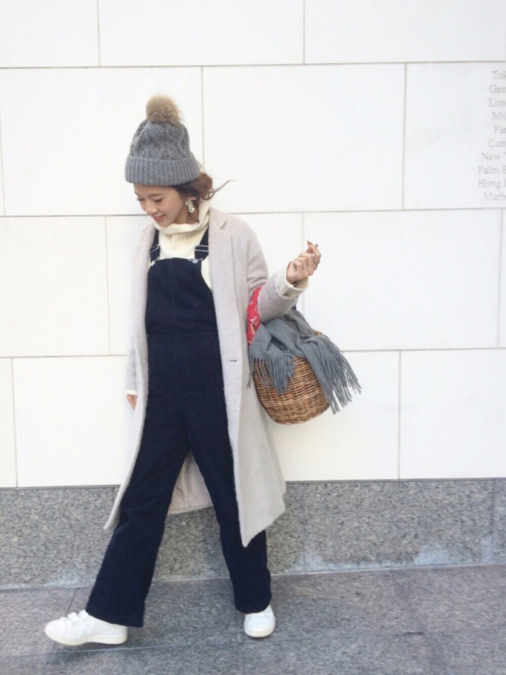ブルー系のサロペット/オーバーオール、グレー系のチェスターコート、ホワイト系のニット/セーターを着用したレディースの冬コーディネートの1枚目の写真