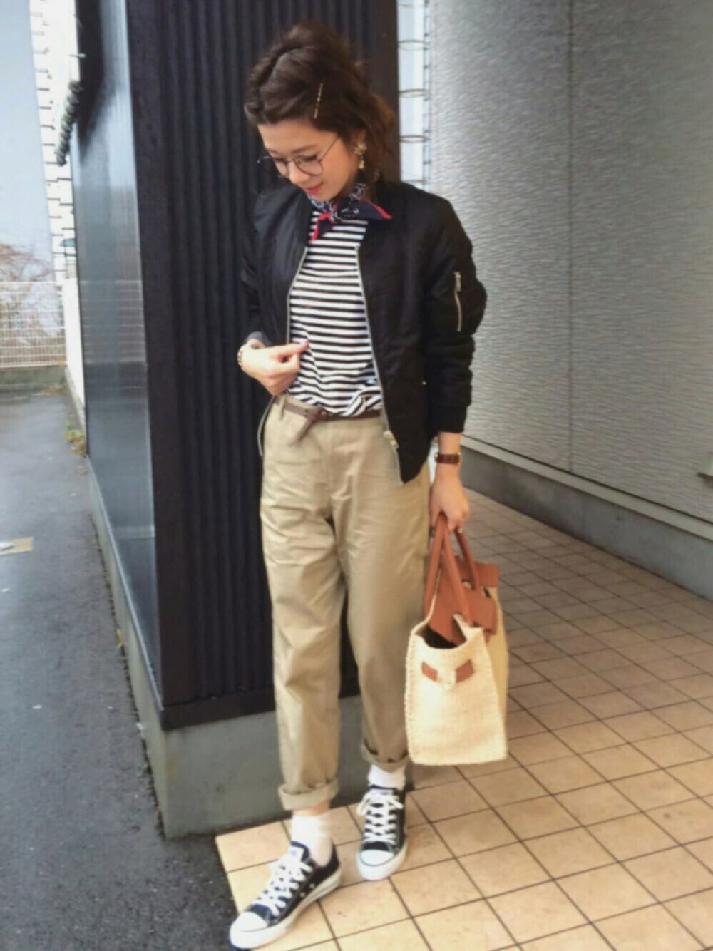 ブラック系のMA-1、ベージュ系のチノパンツ、ブラック系のスニーカーを着用したレディースの冬コーディネートの1枚目の写真