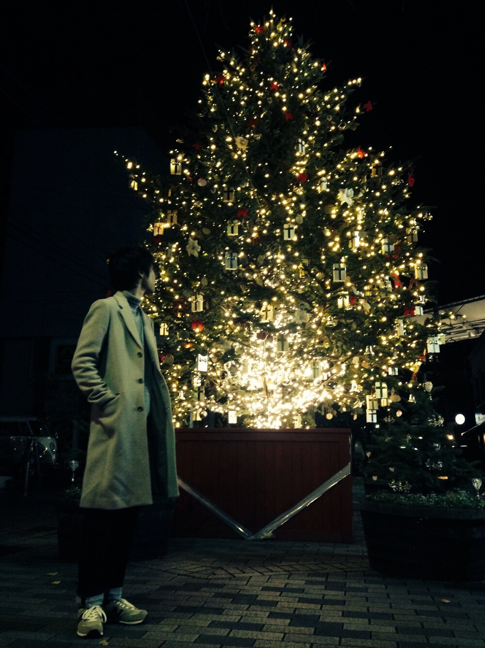 グレー系のニット/セーター、ベージュ系のチェスターコート、ブルー系のその他パンツを着用したメンズの冬コーディネートの1枚目の写真