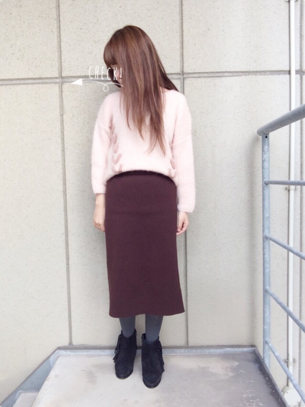ピンク系のニット/セーター、ブラウン系のスカート、ブラック系のブーツを着用したレディースの秋コーディネートの1枚目の写真