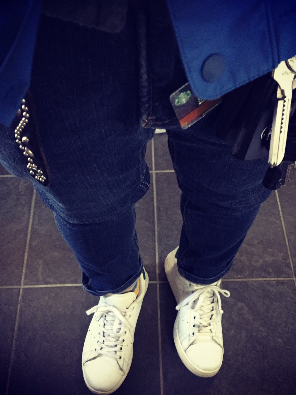 グレー系のニット/セーター、ホワイト系のスニーカー、ブルー系のマウンテンパーカーを着用したメンズの冬コーディネートの1枚目の写真