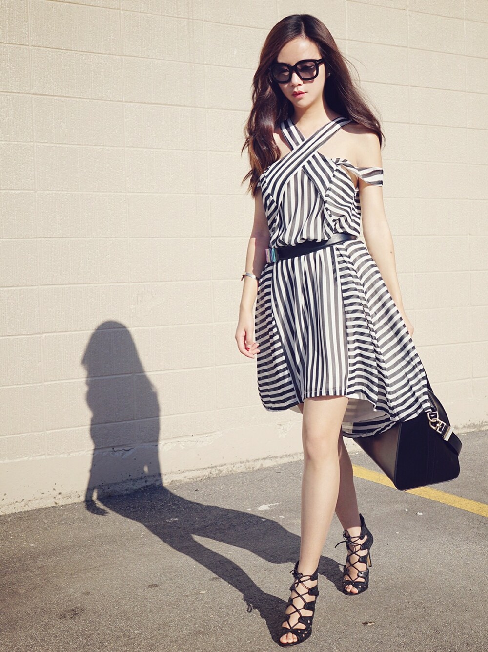 ブラック系のパンプス、ホワイト系のスカートを着用したレディースの夏コーディネートの1枚目の写真