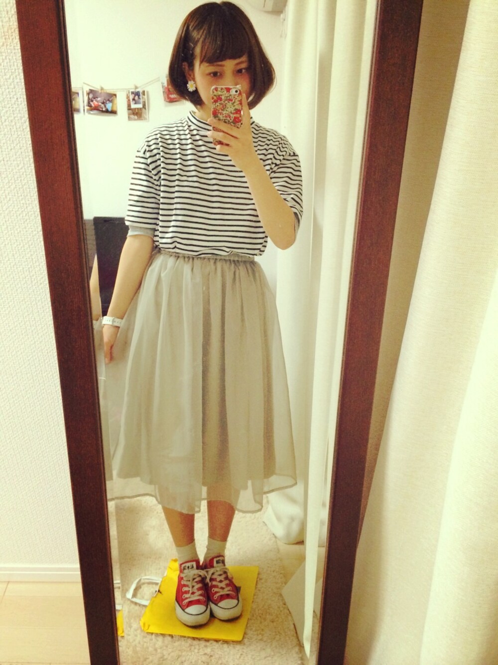 レッド系のスニーカー、グリーン系のスカートを着用したレディースの春コーディネートの1枚目の写真