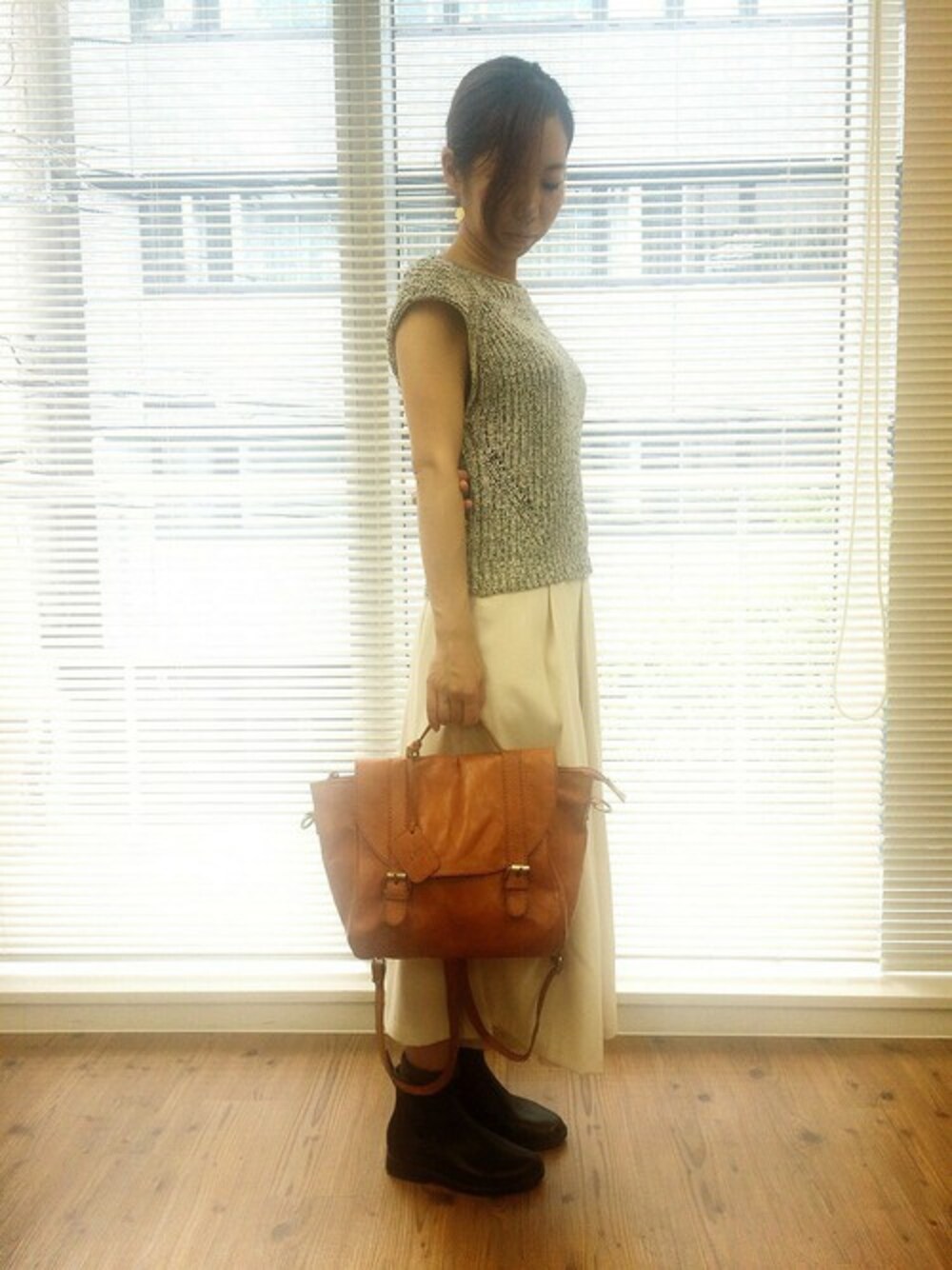 ブラウン系のハンドバッグを着用したレディースの秋コーディネートの1枚目の写真