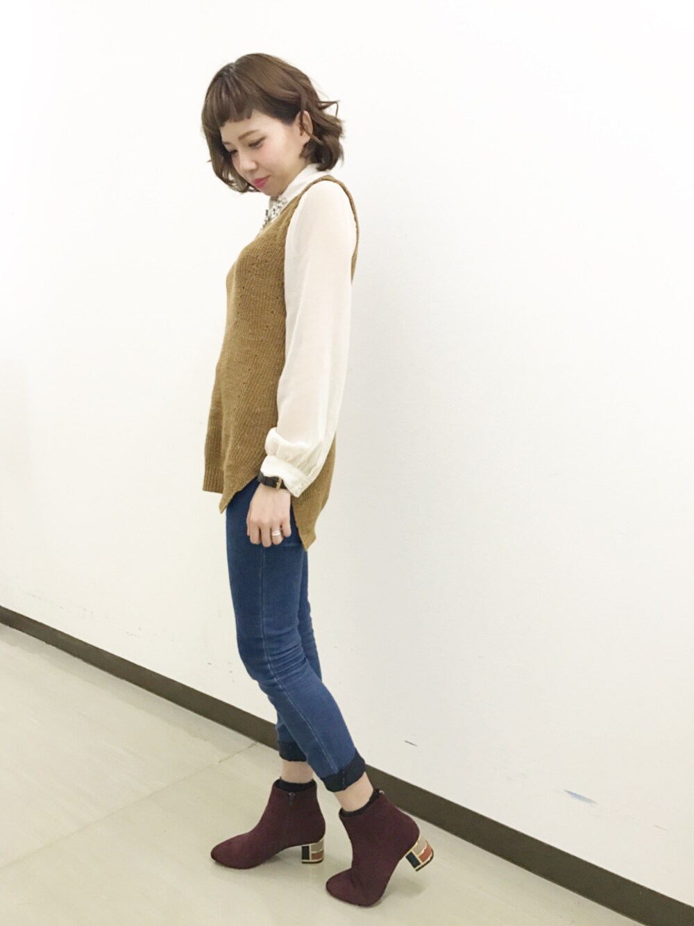 レッド系のブーツを着用したレディースの秋コーディネートの1枚目の写真