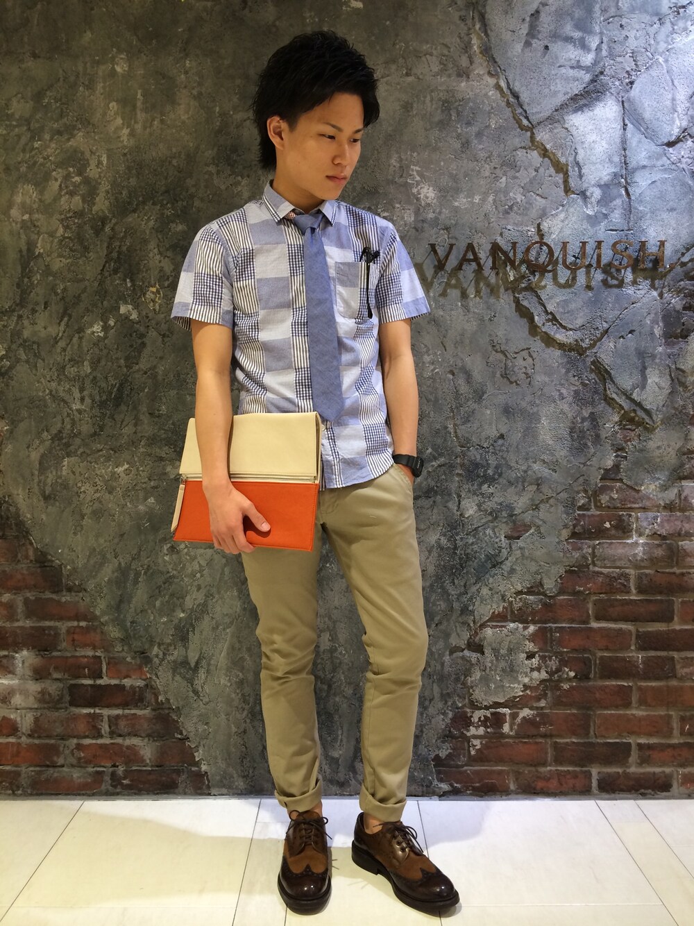 「クラッチバッグ、チノパン、ネイビー、VANQUISH、パッチワーク、ネクタイ、ダテメガネ、CHEANEY」｜「VANQUISHのパッチワークパターン半袖シャツ（シャツ/ブラウス、ブルー系）」を使った、高村 拓弥さん（メンズ・170cm）の夏コーディネートの1枚目の写真