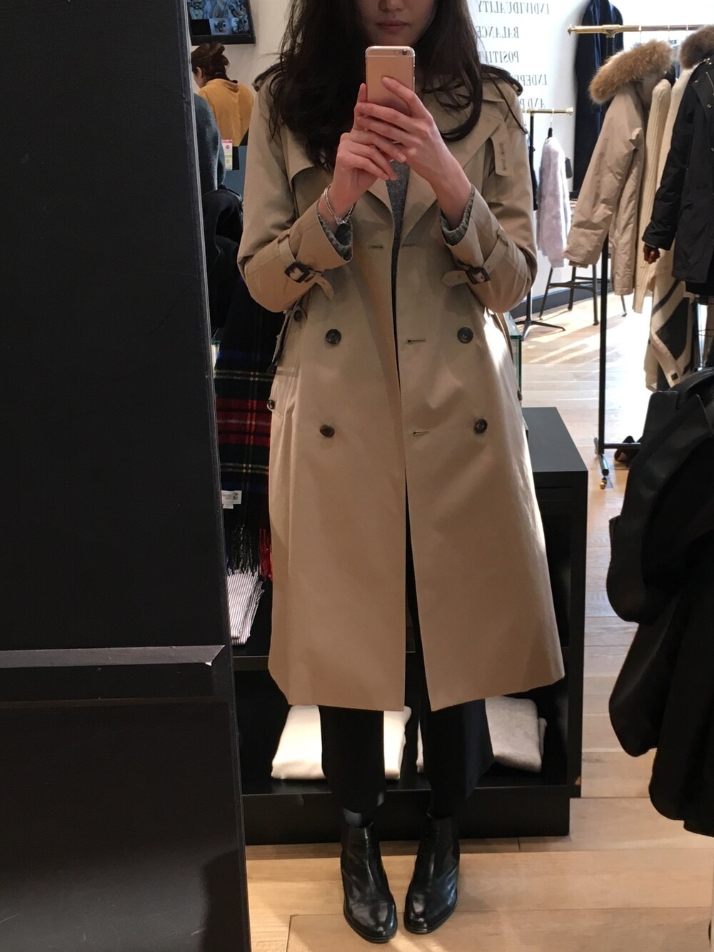 ベージュ系のトレンチコート、ブラック系のその他パンツ、ブラック系のブーツを着用したレディースの冬コーディネートの1枚目の写真