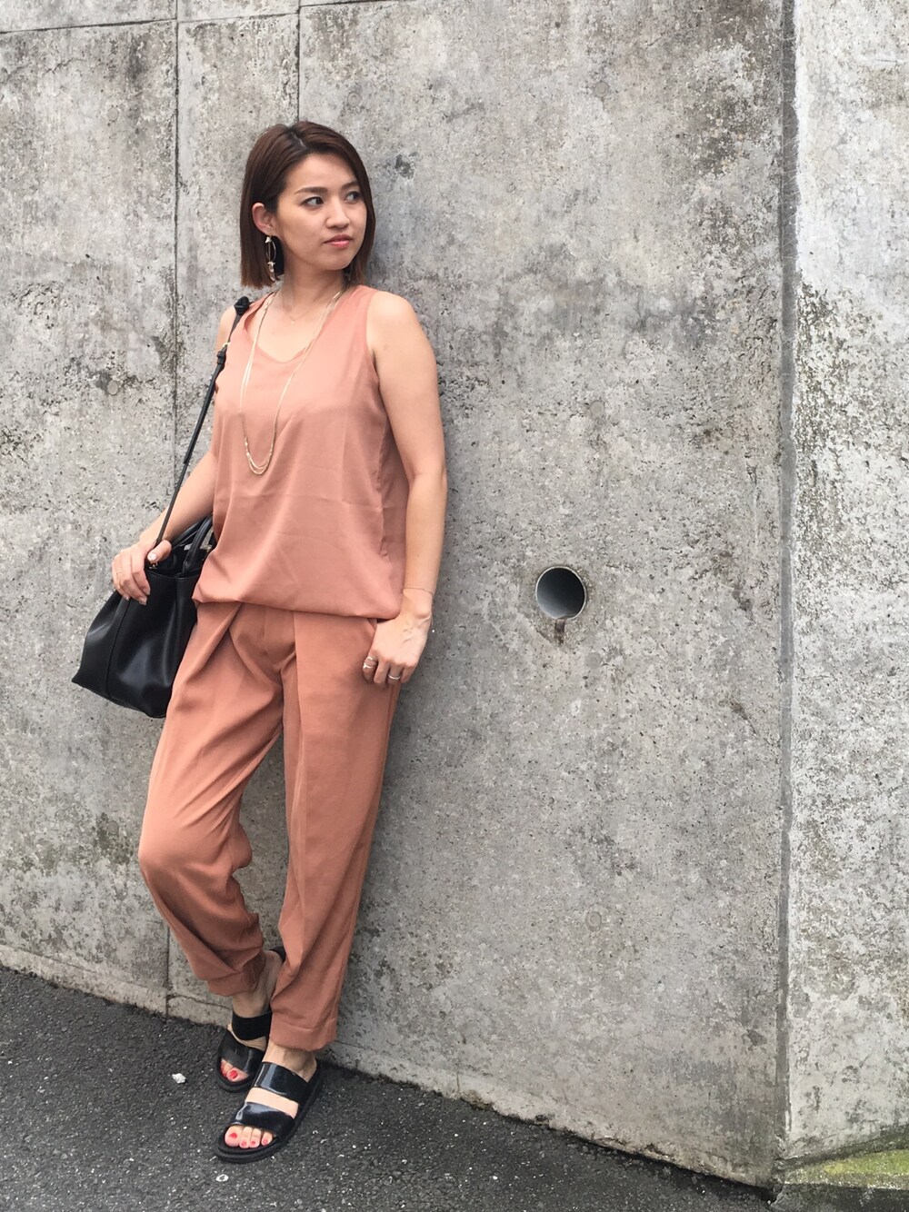 ブラック系のショルダーバッグ、ブラック系のサンダル、ゴールド系のネックレスを着用したレディースの夏コーディネートの1枚目の写真