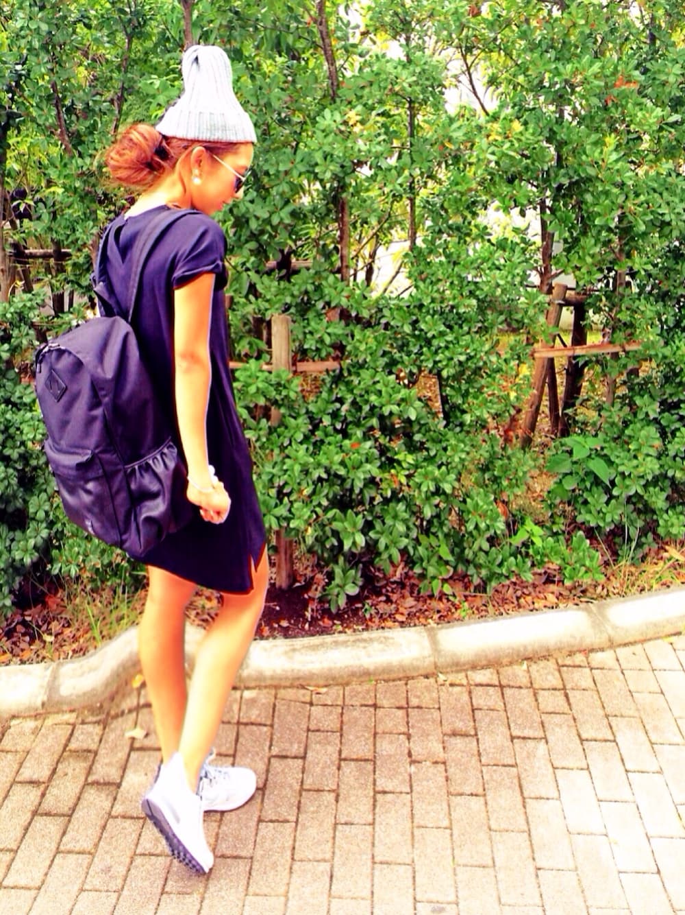 ブラック系のワンピース、ブラック系のバッグ、グレー系のスニーカーを着用したレディースの夏コーディネートの1枚目の写真