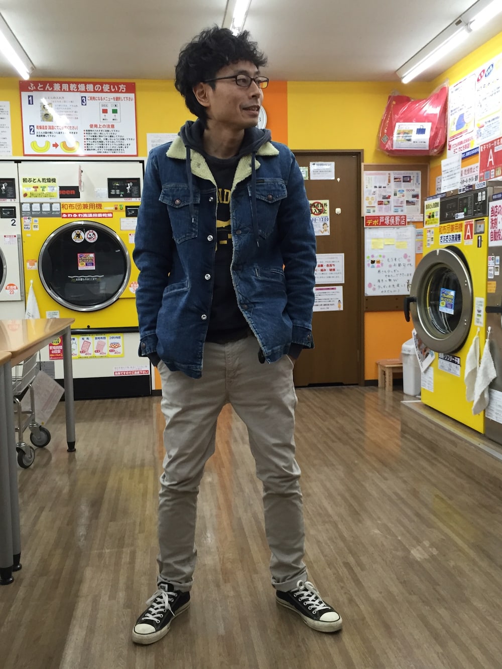 ブルー系のブルゾン、ブルー系のパーカー、ベージュ系のチノパンツを着用したメンズの冬コーディネートの1枚目の写真