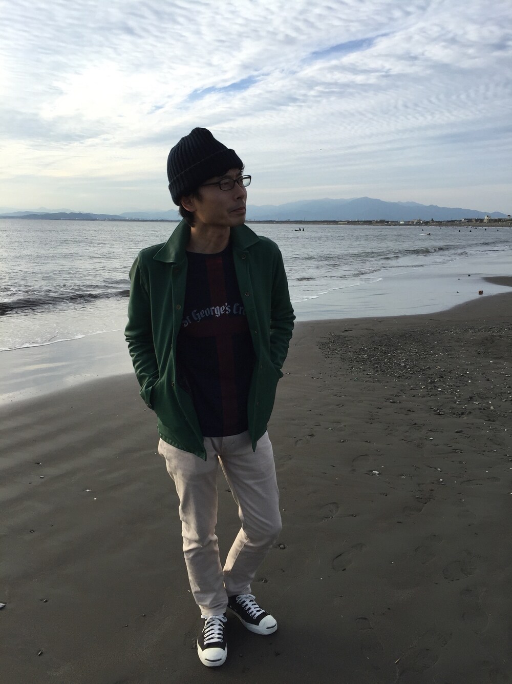 グリーン系のブルゾン、ブルー系のTシャツ/カットソー、ベージュ系のチノパンツを着用したメンズの秋コーディネートの1枚目の写真