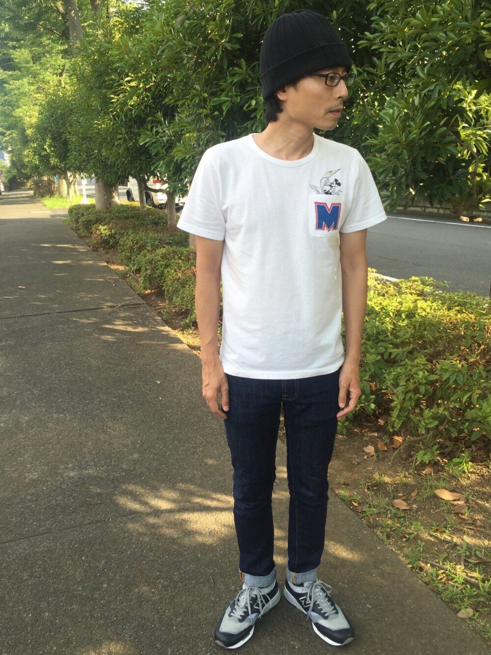 ブラック系のスニーカー、ブルー系のデニムパンツ、ホワイト系のTシャツ/カットソーを着用したメンズの夏コーディネートの1枚目の写真