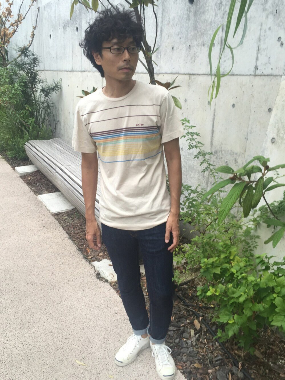 ベージュ系のTシャツ/カットソー、ブルー系のデニムパンツ、ホワイト系のスニーカーを着用したメンズの夏コーディネートの1枚目の写真