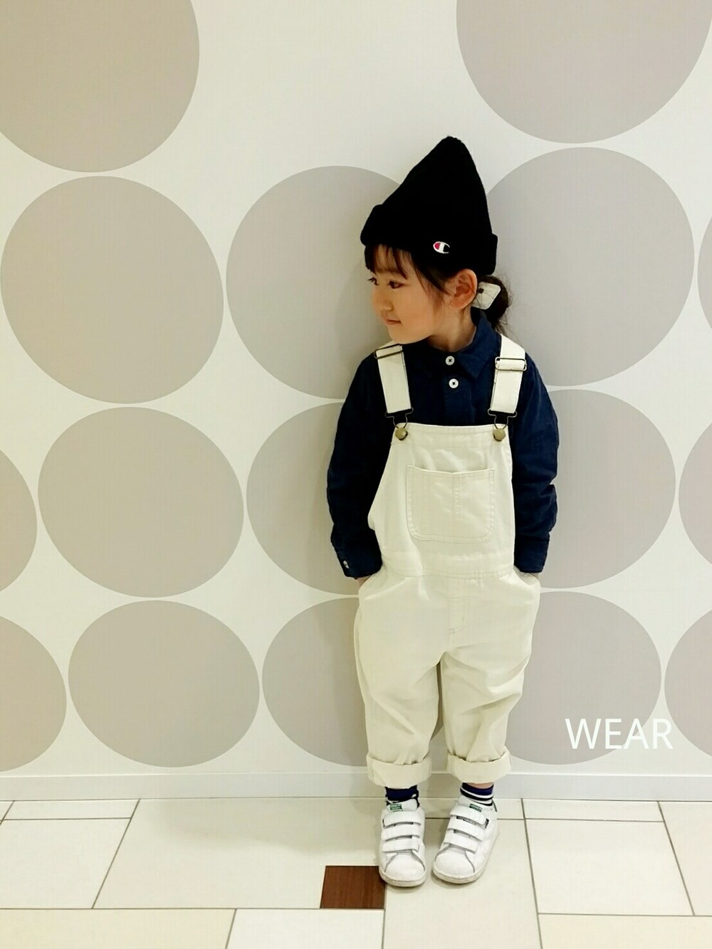 ホワイト系のサロペット/オーバーオール、ホワイト系のスニーカー、ブラック系の帽子を着用したキッズの冬コーディネートの1枚目の写真