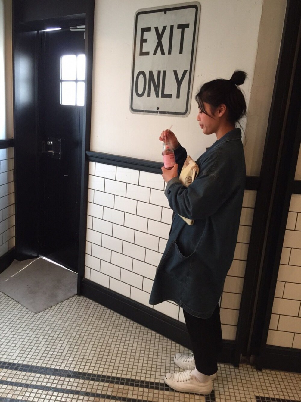 ブラック系のその他パンツ、ベージュ系のクラッチバッグ、ホワイト系のスニーカーを着用したレディースの春コーディネートの1枚目の写真