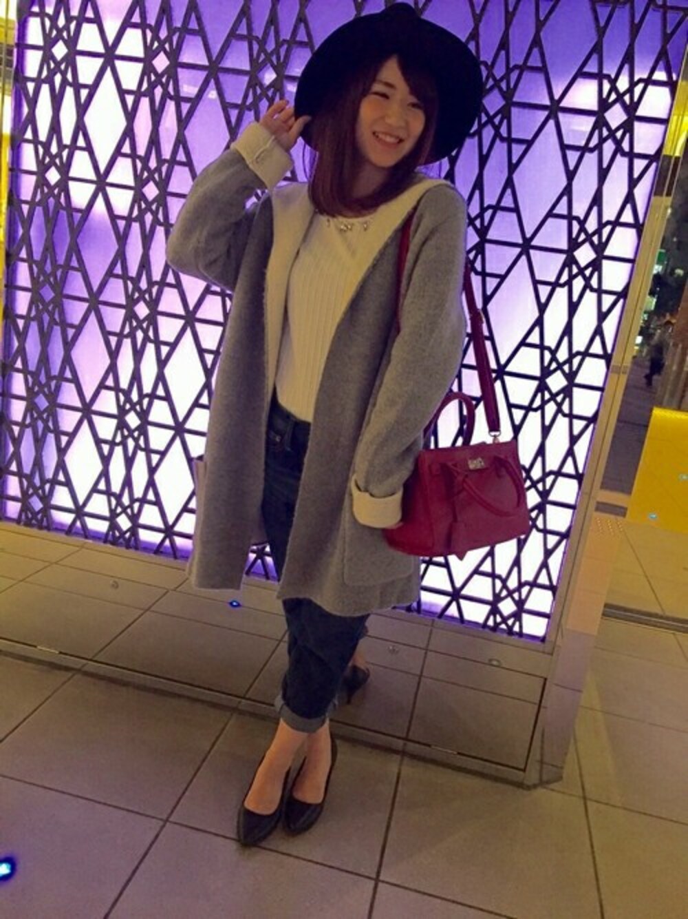 グレー系のカーディガン/ボレロ、ホワイト系のTシャツ/カットソー、ブルー系のデニムパンツを着用したレディースの秋コーディネートの1枚目の写真