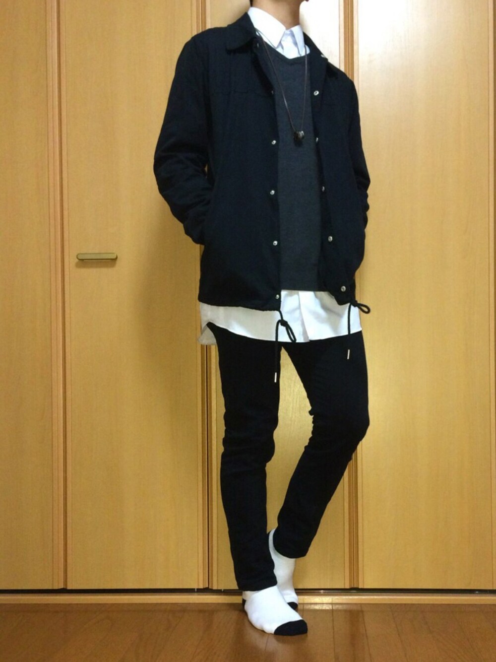 ブラック系のその他パンツ、グレー系のニット/セーター、ブラック系のナイロンジャケットを着用したメンズの秋コーディネートの1枚目の写真