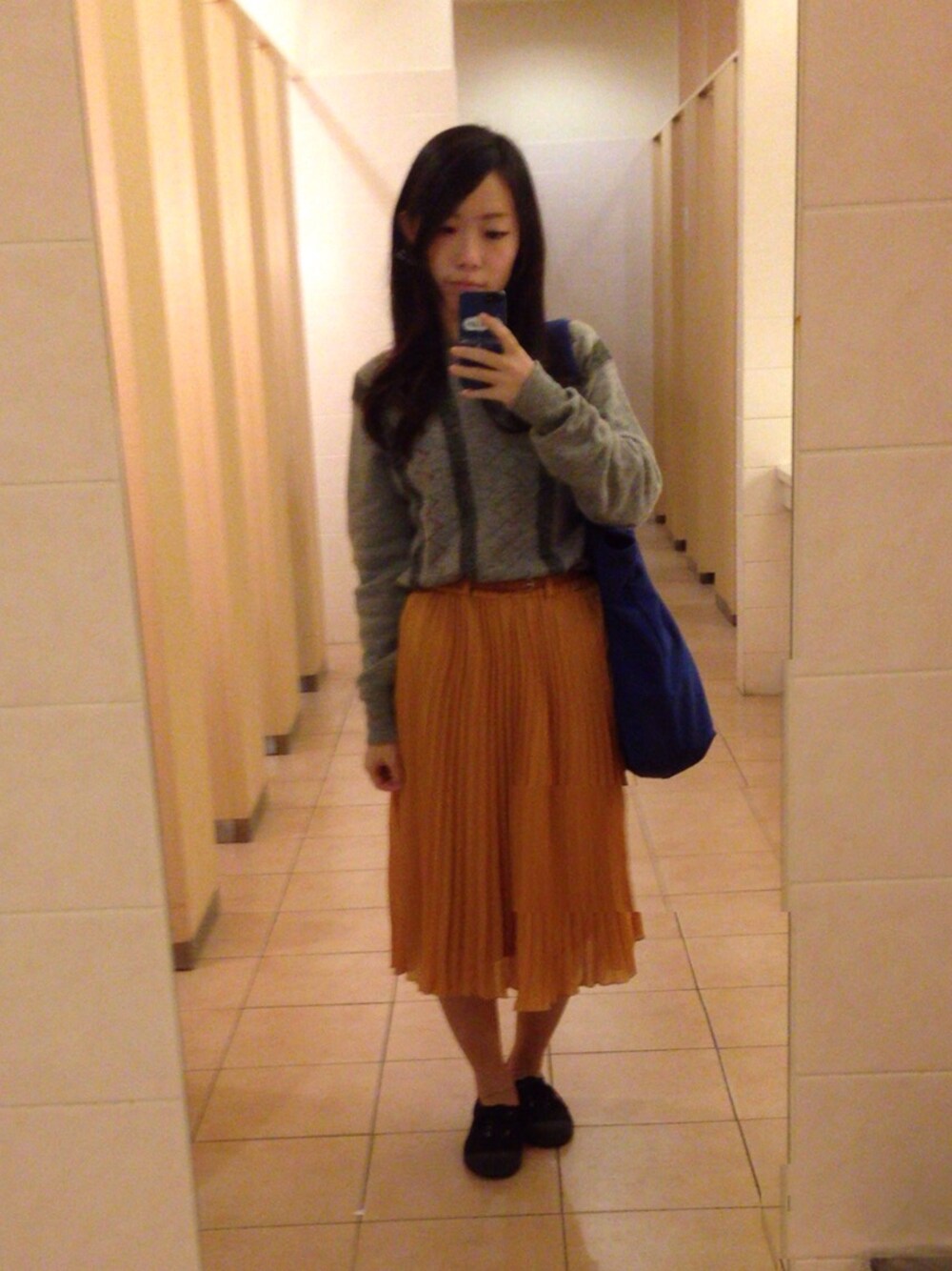 イエロー系のスカートを着用したレディースの秋コーディネートの1枚目の写真