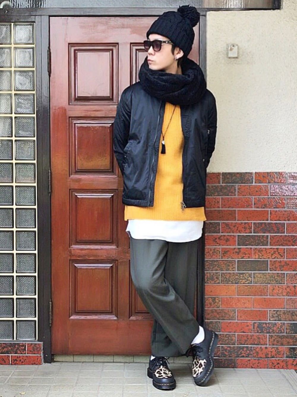 ブラック系のブーツ、グリーン系のスラックス、ホワイト系のTシャツ/カットソーを着用したメンズの秋コーディネートの1枚目の写真