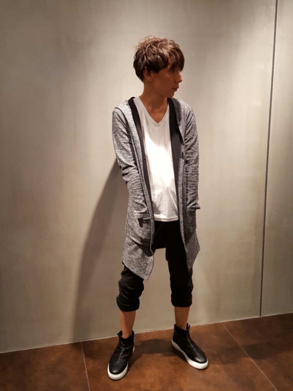 グレー系のパーカー、ブラック系のスニーカー、ホワイト系のTシャツ/カットソーを着用したメンズの秋コーディネートの1枚目の写真
