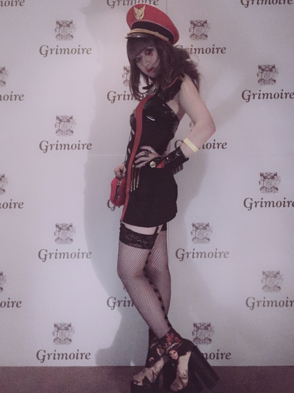 レッド系のハンドバッグ、ブラック系のブーツ、レッド系のハットを着用したレディースの秋コーディネートの1枚目の写真