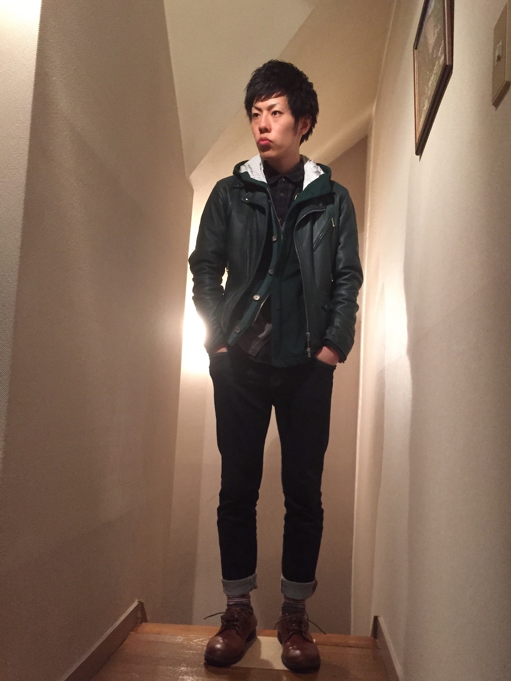 グリーン系のライダースジャケット、グリーン系のブルゾン、グレー系のカーディガン/ボレロを着用したメンズの冬コーディネートの1枚目の写真
