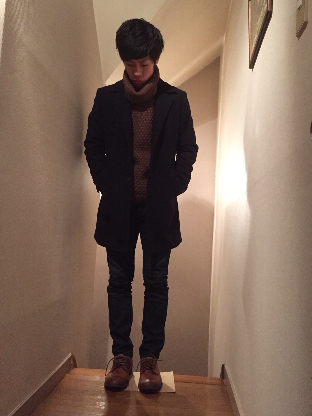 ブルー系のチェスターコート、ブラウン系のニット/セーター、ブルー系のその他パンツを着用したメンズの冬コーディネートの1枚目の写真