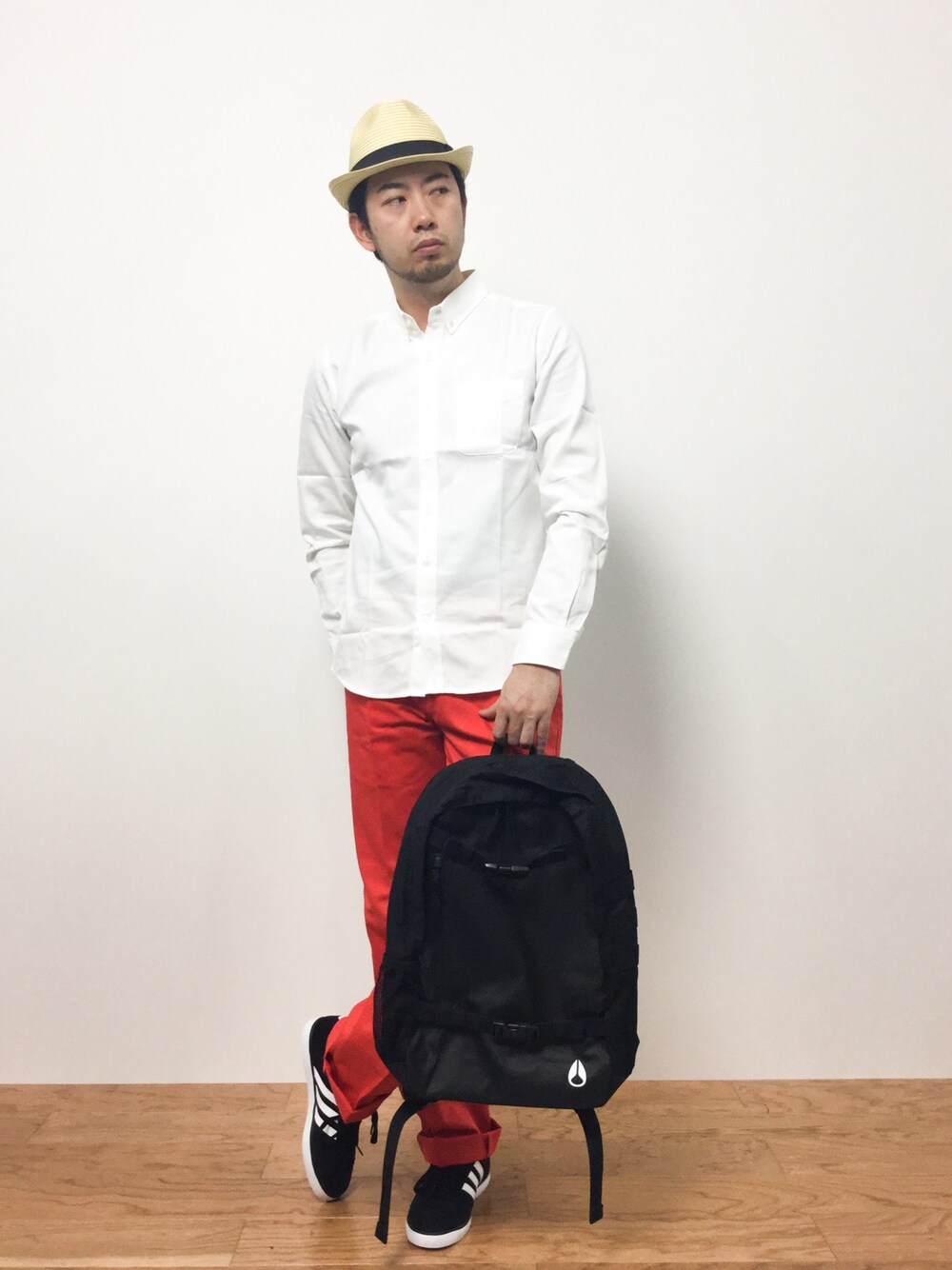 ホワイト系のシャツ/ブラウス、オレンジ系のチノパンツ、ブラック系のバックパック/リュックを着用したメンズの夏コーディネートの1枚目の写真