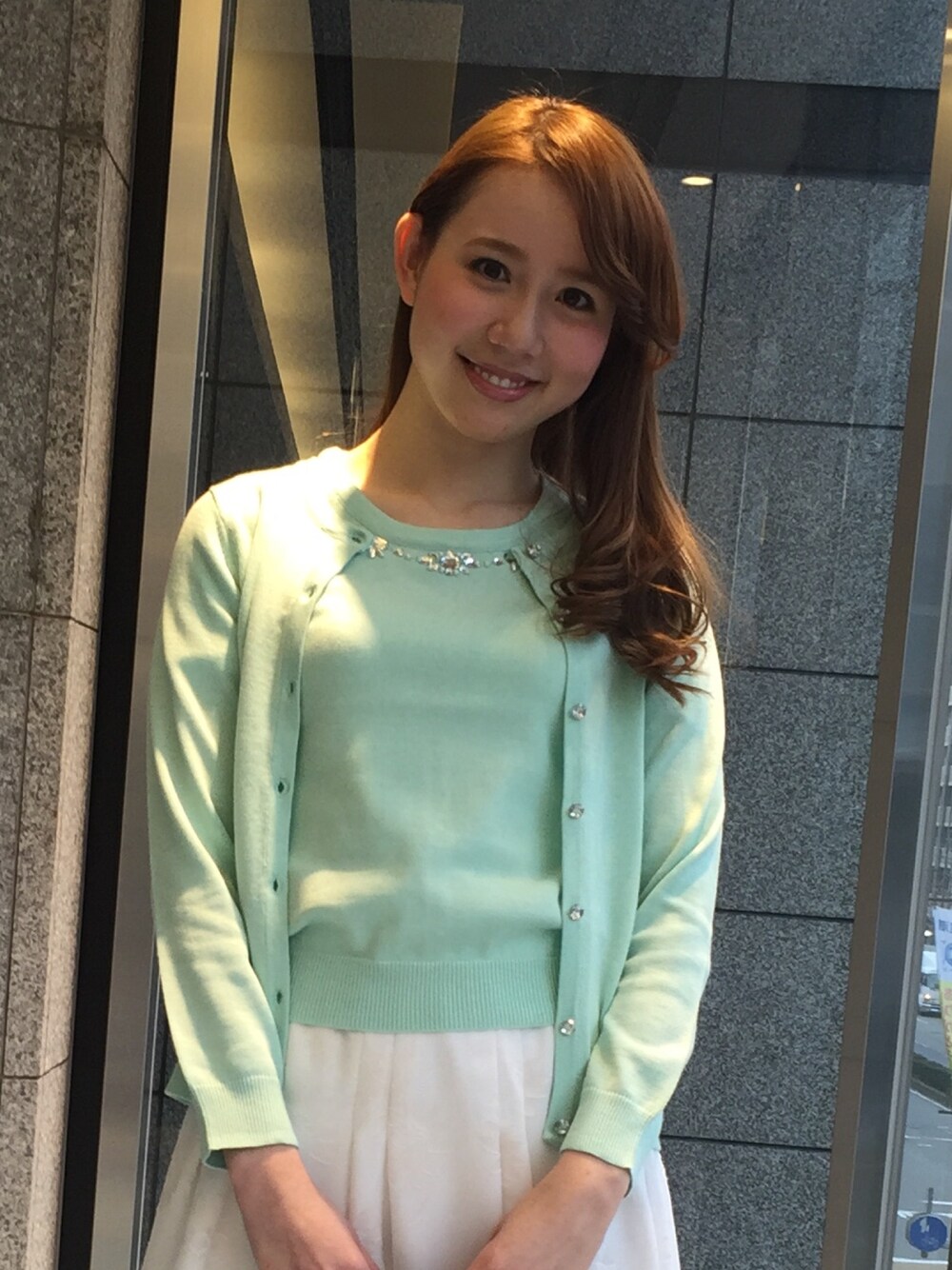 グリーン系のアンサンブルを着用したレディースの冬コーディネートの1枚目の写真