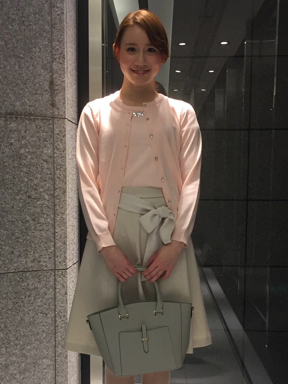 ピンク系のアンサンブルを着用したレディースの冬コーディネートの1枚目の写真