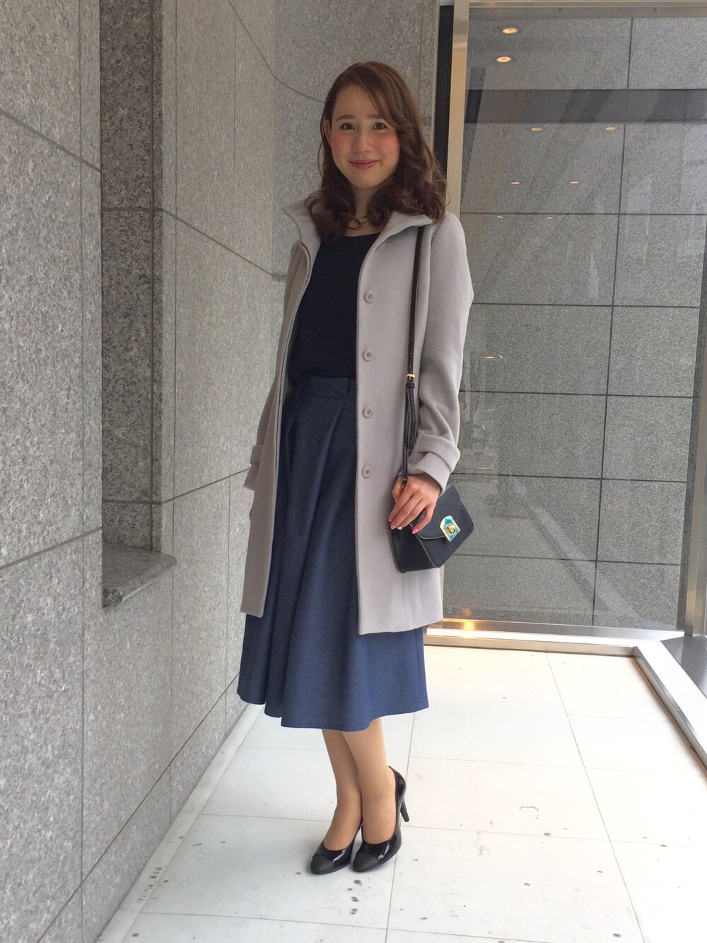 グレー系のステンカラーコートを着用したレディースの夏コーディネートの1枚目の写真