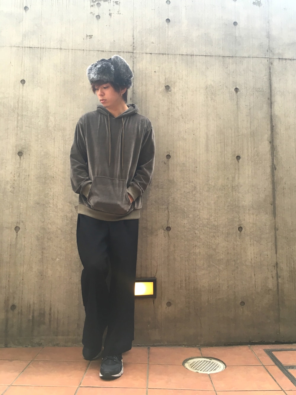 グリーン系のパーカー、ブラック系のパンツ、ブラック系のスニーカーを着用したメンズの秋コーディネートの1枚目の写真