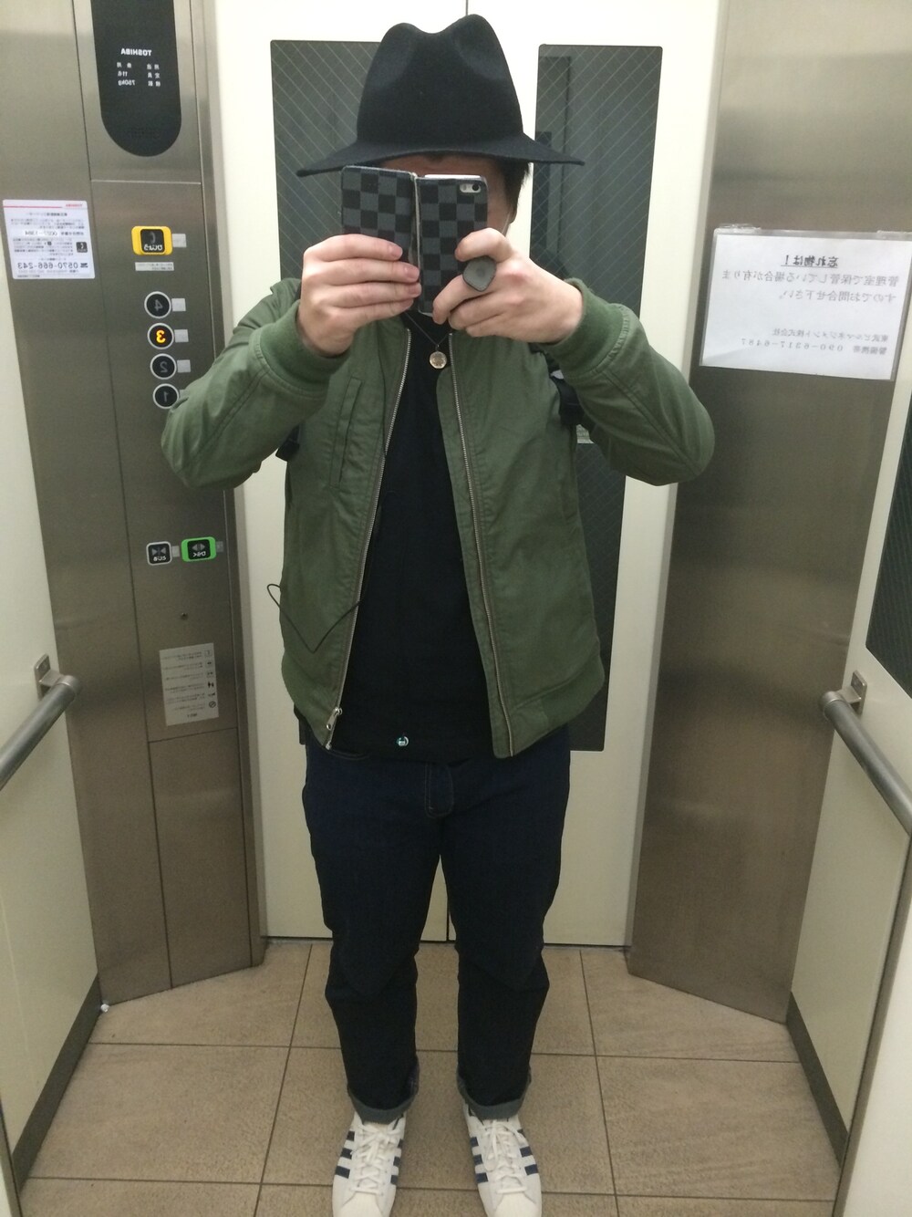 グリーン系のブルゾン、ブラック系のTシャツ/カットソー、ブルー系のデニムパンツを着用したメンズの冬コーディネートの1枚目の写真