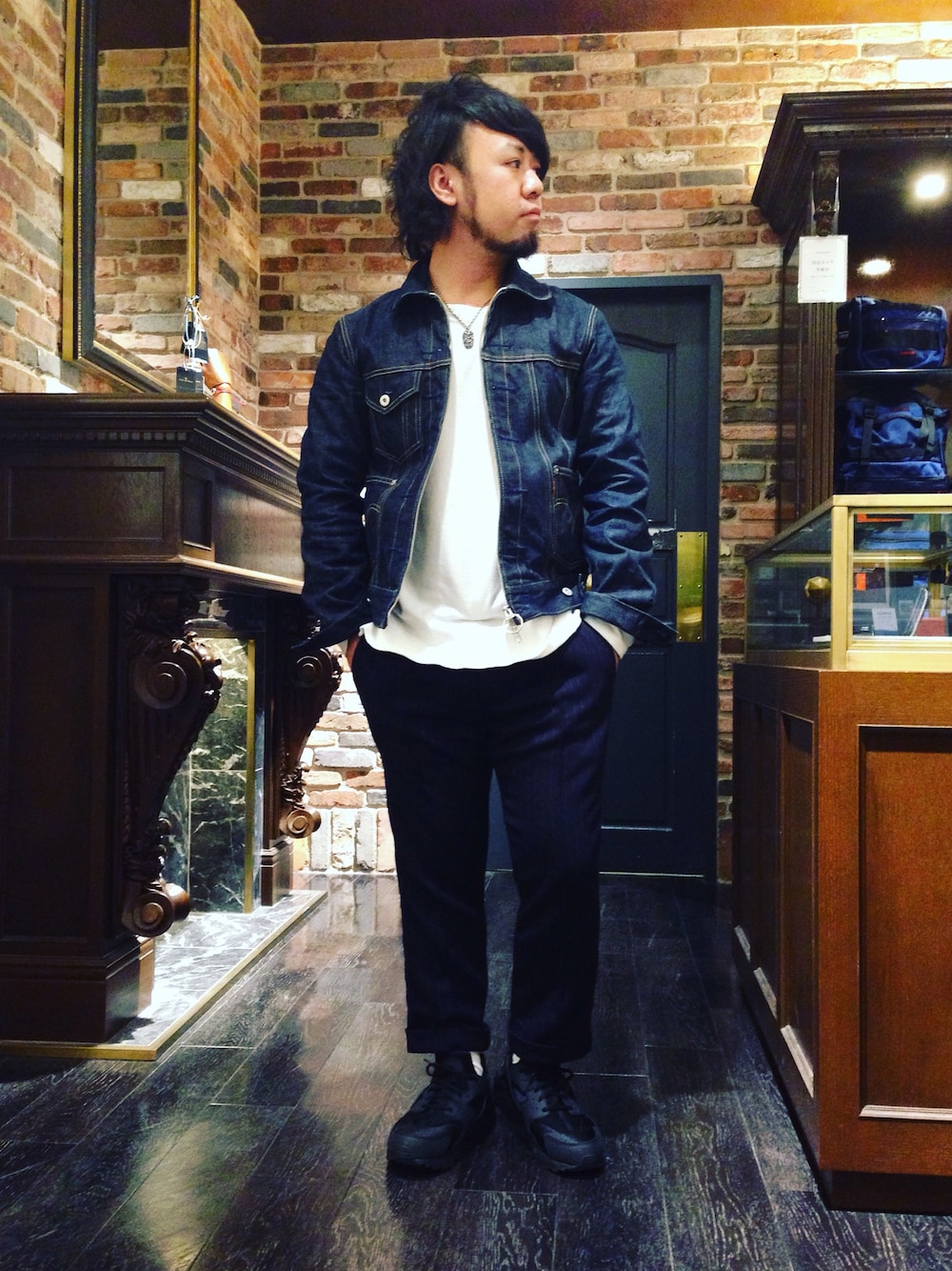 ブラック系のスニーカー、ホワイト系のTシャツ/カットソー、ブラック系のパンツを着用したメンズの秋コーディネートの1枚目の写真