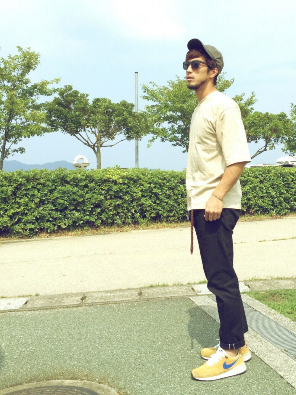 ブラック系のその他パンツ、ベージュ系のTシャツ/カットソー、イエロー系のスニーカーを着用したメンズの秋コーディネートの1枚目の写真