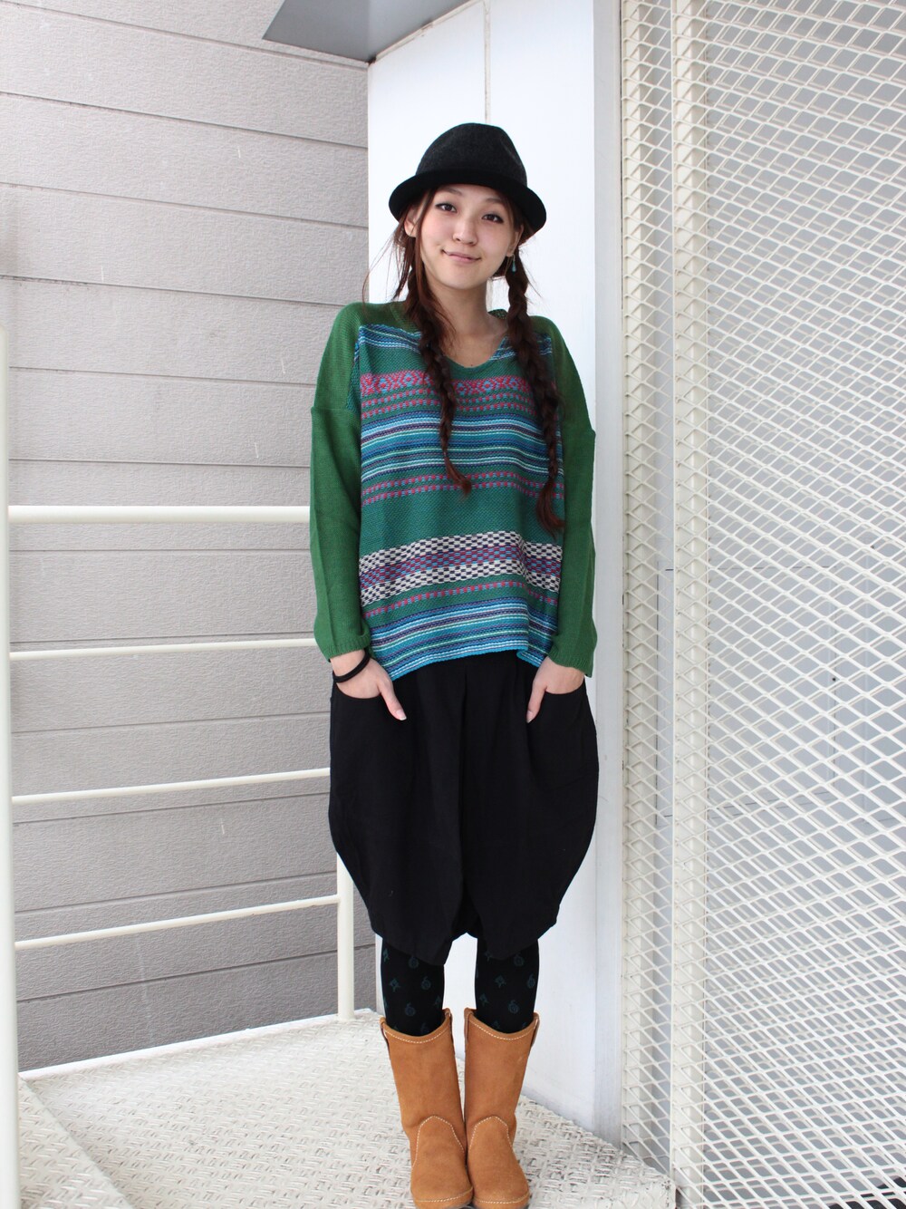 グリーン系のニット/セーター、ブラック系のその他パンツ、ブラウン系のブーツを着用したレディースの秋コーディネートの1枚目の写真